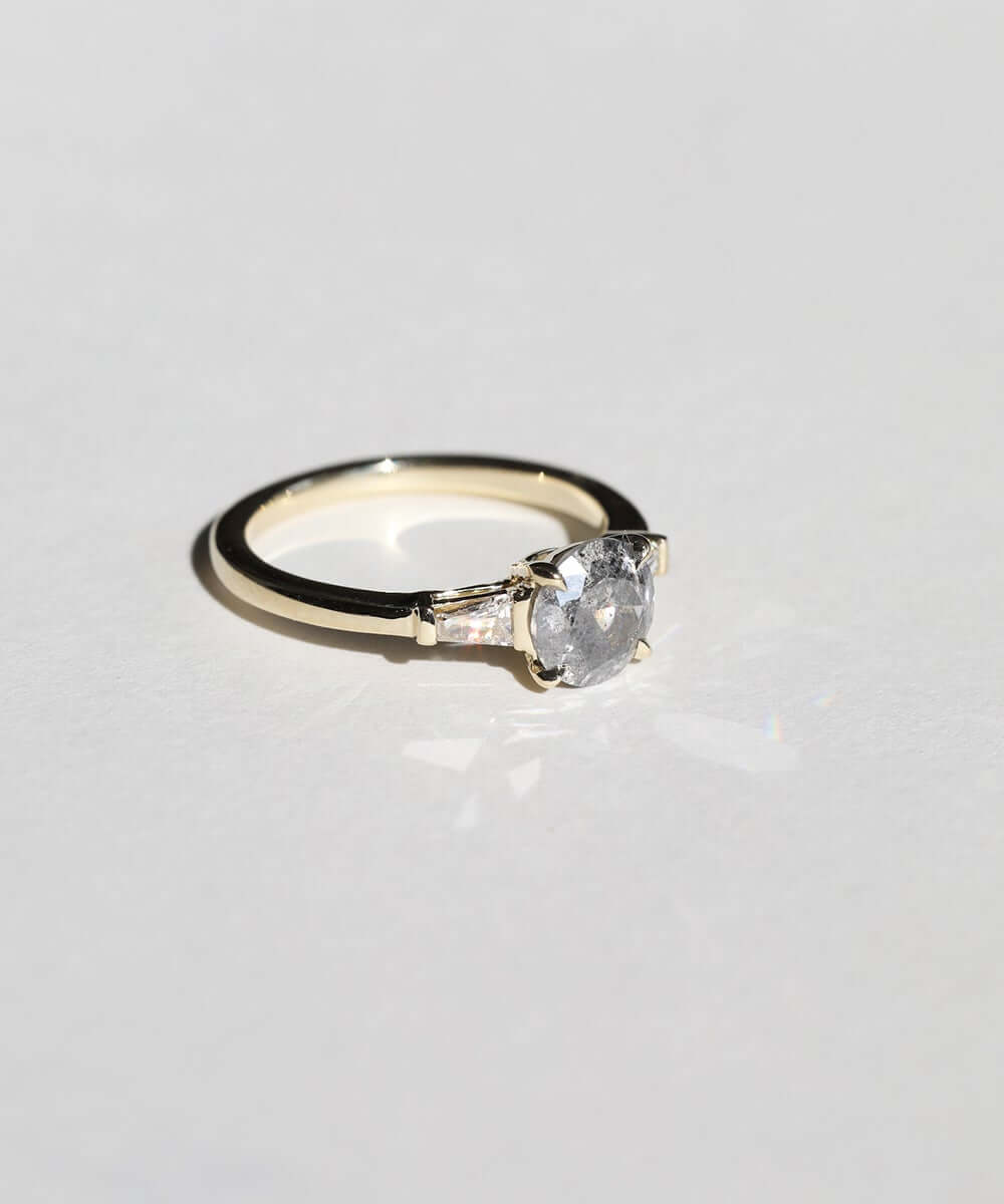semi-translucent salt n pepper diamond engagement ring accented by white tapered baguettes set in 14k gold band macha studio brooklyn new york