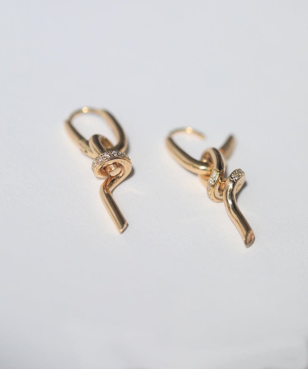 A loose knot pendant hangs from a hinged drop earring in 14k gold with pavé set diamonds.  Knot can also be worn as a pendant.