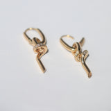 A loose knot pendant hangs from a hinged drop earring in 14k gold with pavé set diamonds.  Knot can also be worn as a pendant.