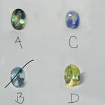 Four oval-cut loose gemstones arranged on a light gray background, labeled A and B. The stones show iridescent color variation: one greenish stone labeled A, one blue-purple stone, one pale blue stone labeled B, and one yellow-green stone.
