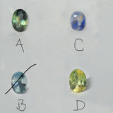 Four oval-cut loose gemstones arranged on a light gray background, labeled A and B. The stones show iridescent color variation: one greenish stone labeled A, one blue-purple stone, one pale blue stone labeled B, and one yellow-green stone.