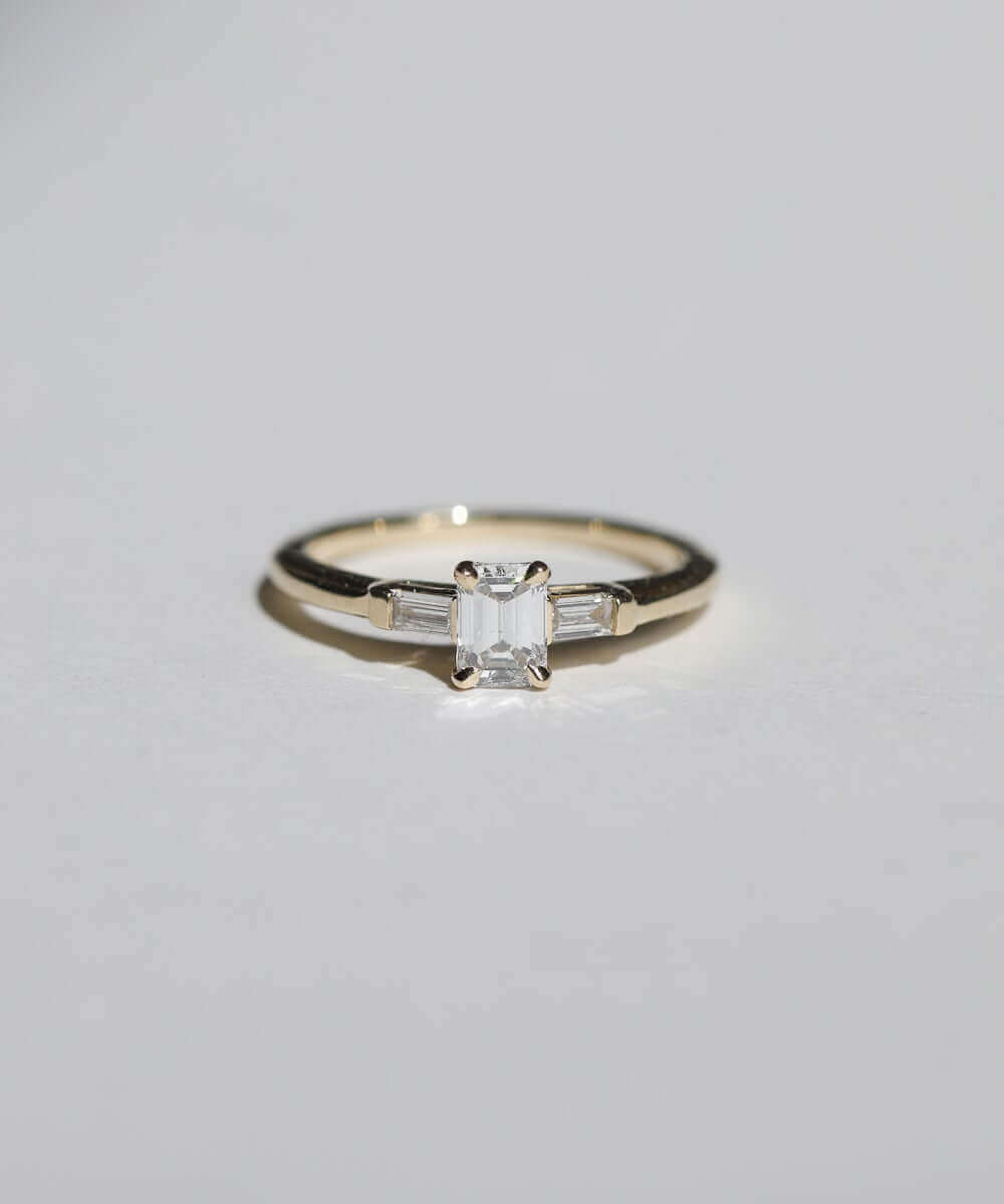 Emerald cut 0.5ct white diamond, with white diamond baguettes set in 14k yellow gold