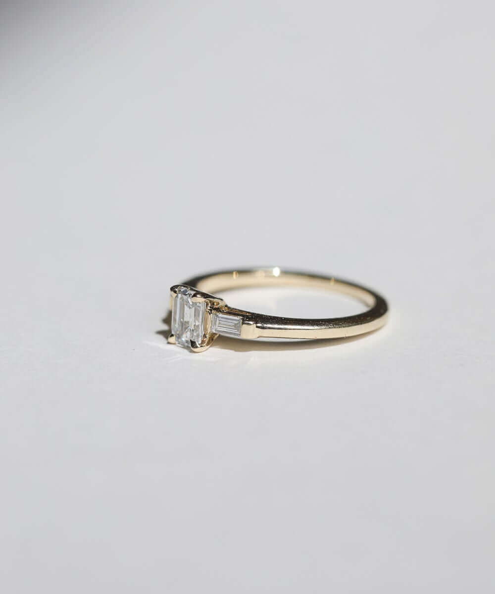 Emerald cut 0.5ct white diamond, with white diamond baguettes set in 14k yellow gold