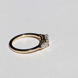 handcrafted white diamond engagement ring featuring large cushion cut center stone accented with two pear shaped stones set in 14k yellow gold band macha studio brooklyn new york