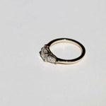 handcrafted white diamond engagement ring featuring large cushion cut center stone accented with two pear shaped stones set in 14k yellow gold band macha studio brooklyn new york