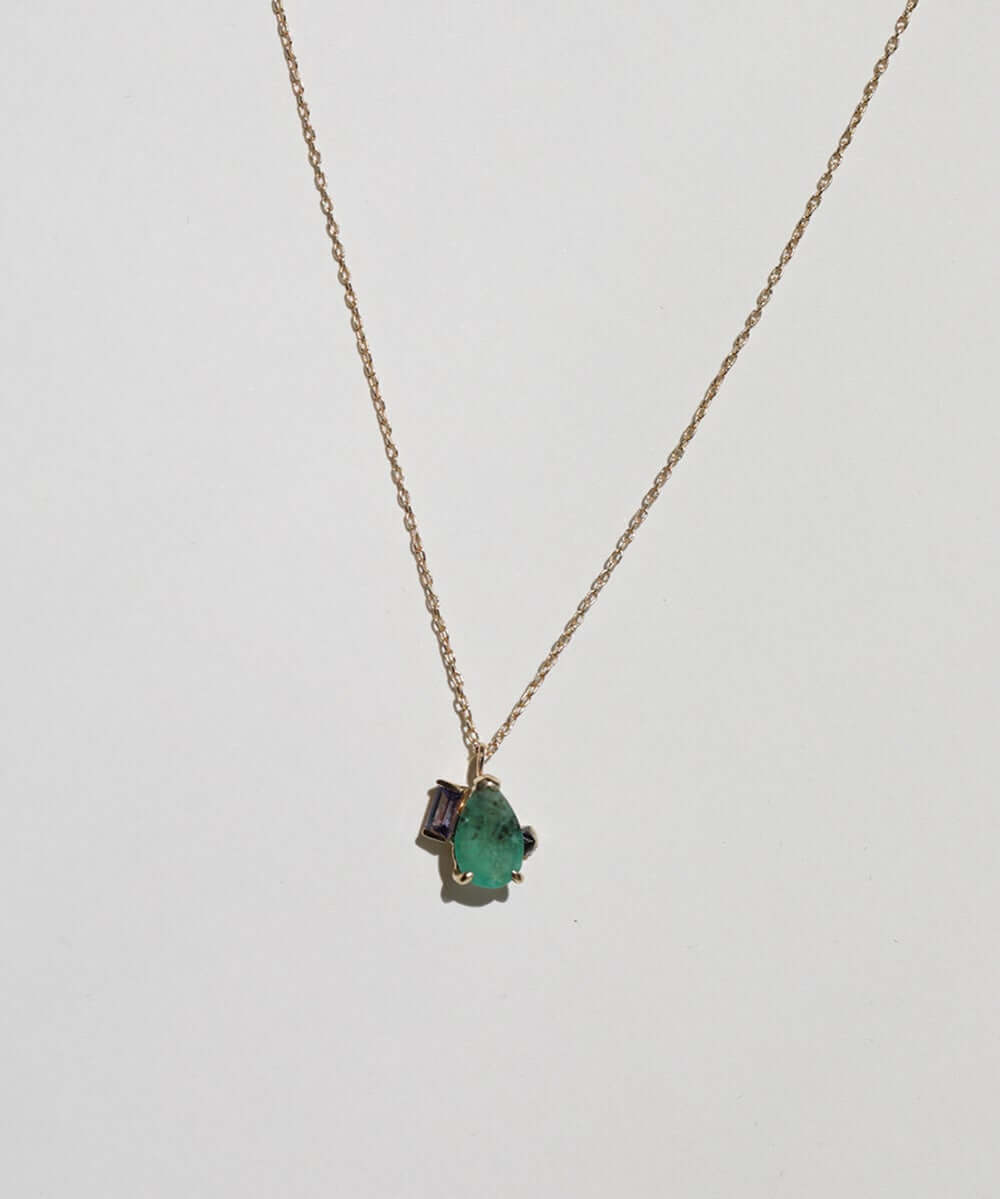 Pear shaped emerald with peppery textures, combined with a purple sapphire and an inverted black emerald cut diamond, 14k gold, 18" chain