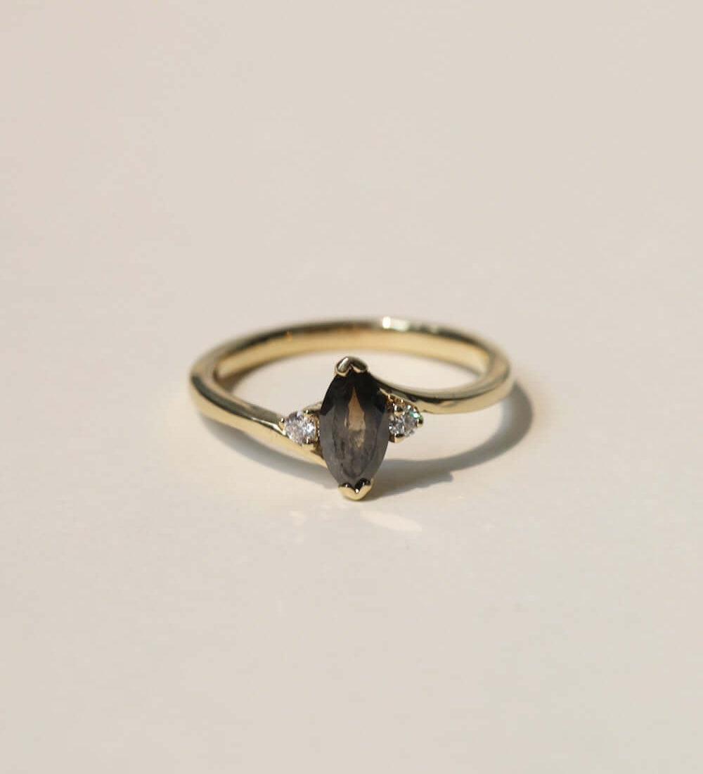 marquise cut salt and pepper diamond with dark warm tones, accented by white diamonds, set in 14k yellow gold