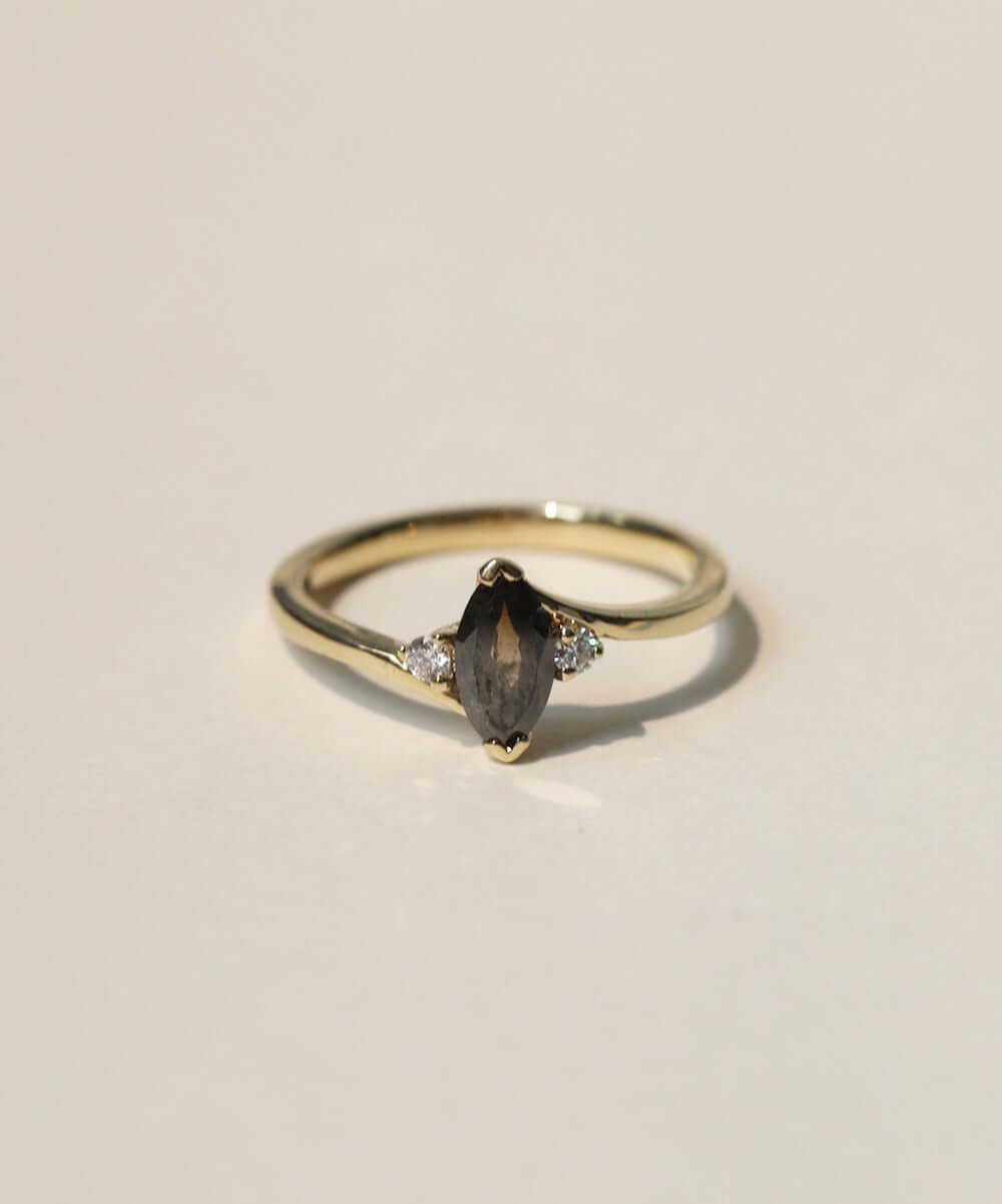 marquise cut salt and pepper diamond with dark warm tones, accented by white diamonds, set in 14k yellow gold
