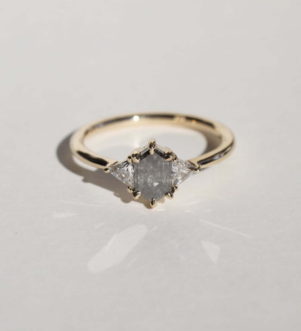 elongated hexagonal cut salt and pepper diamond accented with aligned trillion cut white diamonds, 14k yellow gold, handcrafted by macha studio brooklyn new york