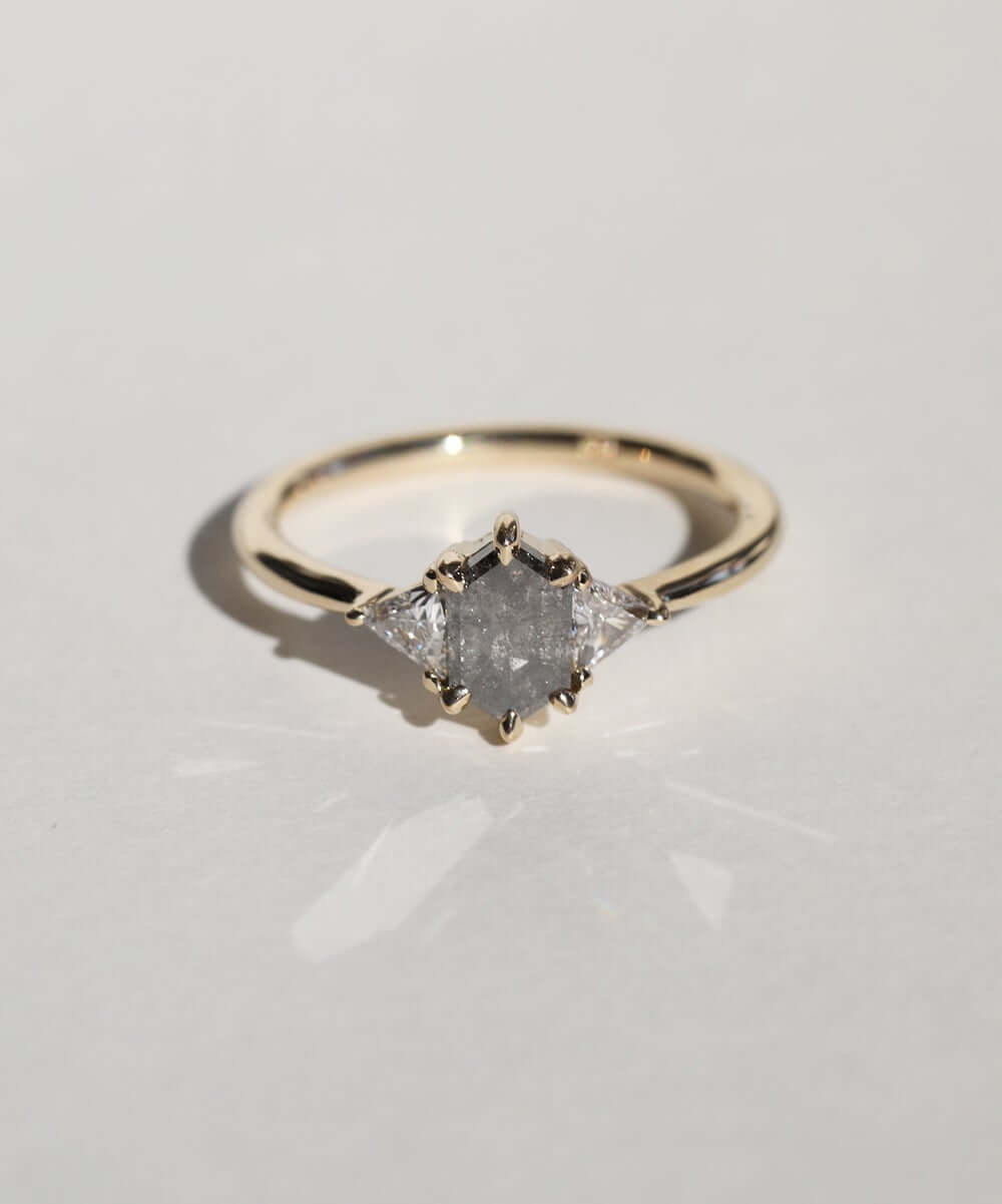 elongated hexagonal cut salt and pepper diamond accented with aligned trillion cut white diamonds, 14k yellow gold, handcrafted by macha studio brooklyn new york