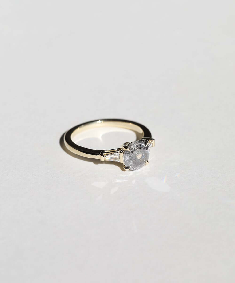 semi-translucent salt n pepper diamond engagement ring accented by white tapered baguettes set in 14k gold band macha studio brooklyn new york